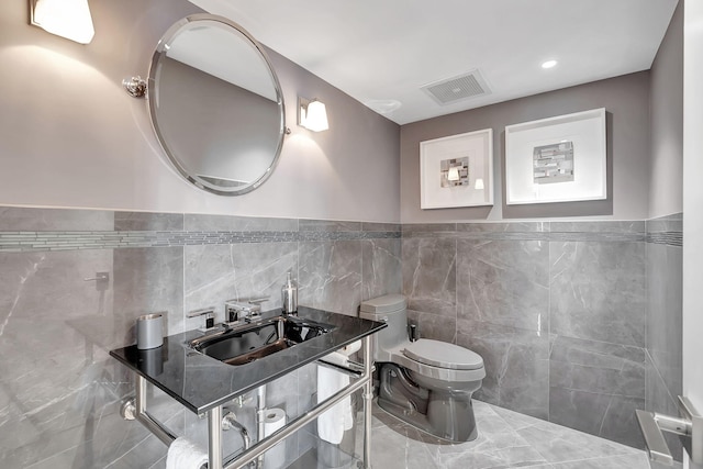 bathroom featuring tile walls, sink, tasteful backsplash, toilet, and tile floors