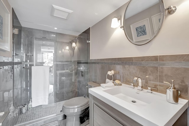 bathroom with tile walls, backsplash, toilet, vanity, and a shower with door