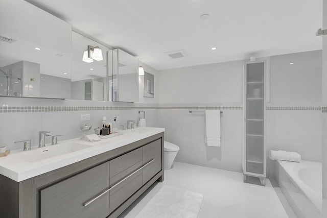 bathroom with tile flooring, oversized vanity, double sink, toilet, and a bathtub