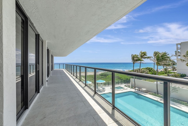 balcony featuring a water view and a fenced in pool