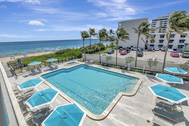 view of pool with a patio and a water view