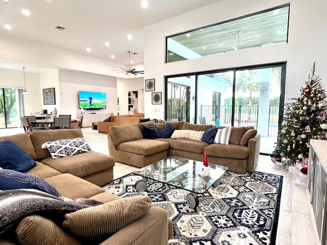 living room featuring ceiling fan and a towering ceiling