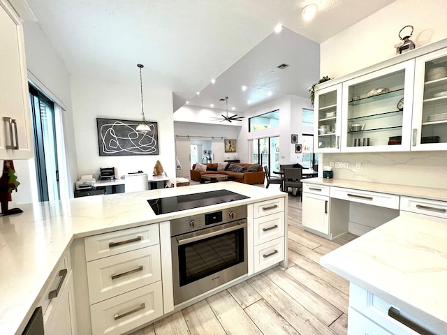 kitchen featuring black electric stovetop, stainless steel oven, ceiling fan, white cabinets, and hanging light fixtures