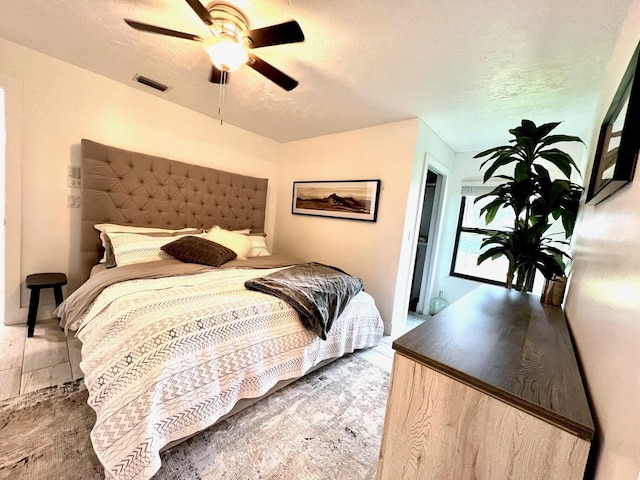 bedroom with ceiling fan and a textured ceiling