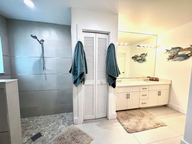 bathroom with tile patterned flooring, vanity, and walk in shower