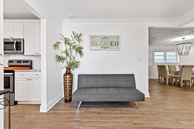 sitting room featuring crown molding, light hardwood / wood-style flooring, and a textured ceiling