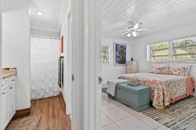 bedroom featuring ceiling fan, light hardwood / wood-style floors, ornamental molding, and wooden ceiling