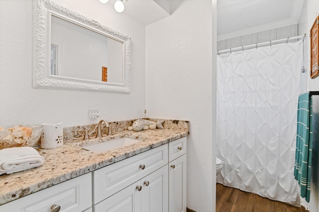 bathroom featuring vanity, toilet, ornamental molding, curtained shower, and wood-type flooring