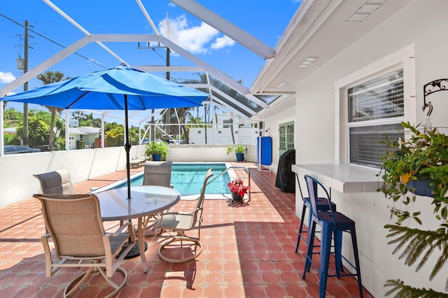 view of swimming pool featuring a lanai, a patio area, and exterior bar