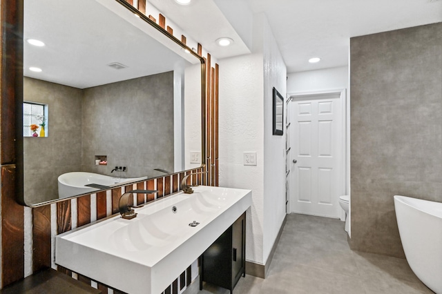 bathroom with toilet, a tub to relax in, and concrete floors