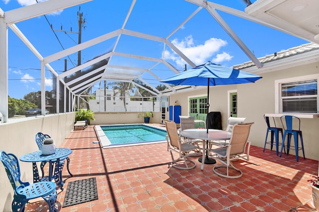 view of swimming pool with glass enclosure, an outdoor bar, and a patio