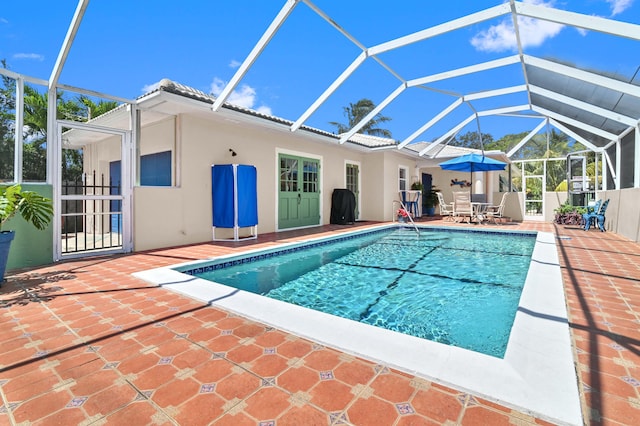 view of swimming pool featuring a patio and glass enclosure