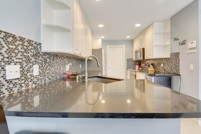 kitchen featuring sink, kitchen peninsula, tasteful backsplash, and stainless steel appliances