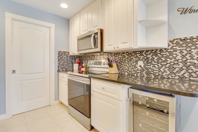 kitchen with wine cooler, white cabinets, light tile flooring, backsplash, and range with electric cooktop