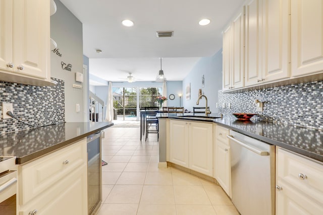 kitchen featuring kitchen peninsula, ceiling fan, tasteful backsplash, sink, and stainless steel dishwasher