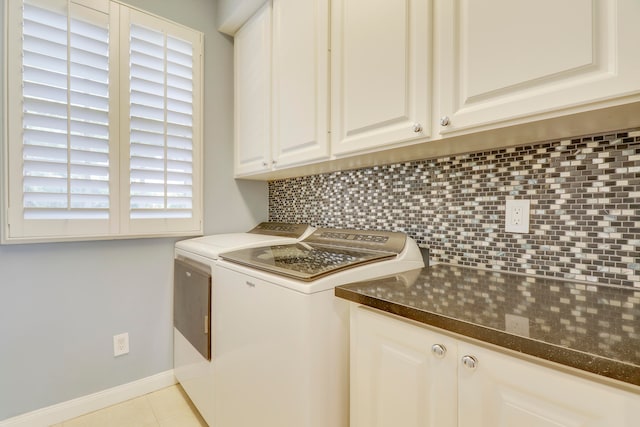 laundry area featuring washer and clothes dryer, cabinets, and light tile floors