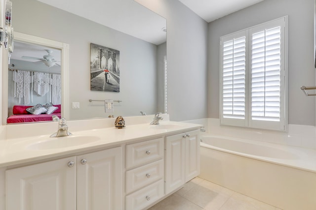 bathroom with tile floors, a healthy amount of sunlight, a washtub, and dual bowl vanity