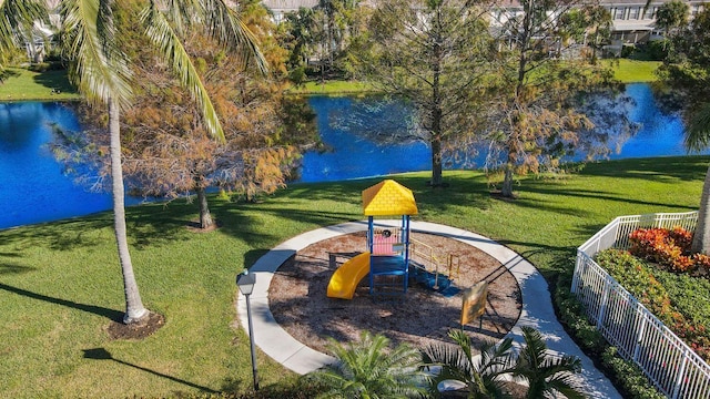 view of property's community with a yard, a playground, and a water view