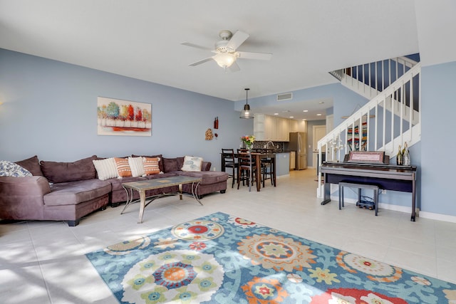 living room with sink, ceiling fan, and light tile floors