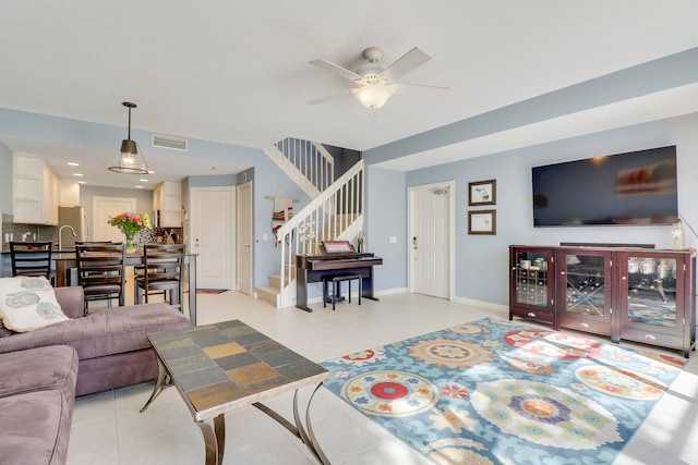 tiled living room featuring ceiling fan and sink