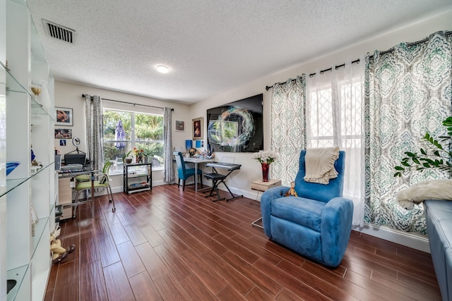 sitting room featuring a textured ceiling and dark hardwood / wood-style flooring