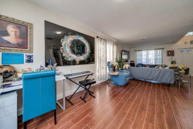 living room featuring wood-type flooring and a textured ceiling