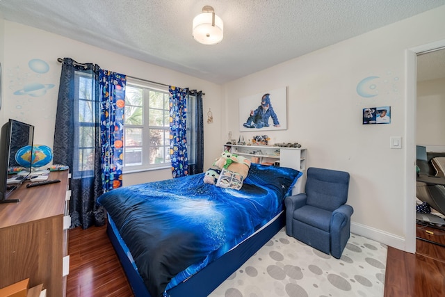 bedroom with a textured ceiling and hardwood / wood-style flooring