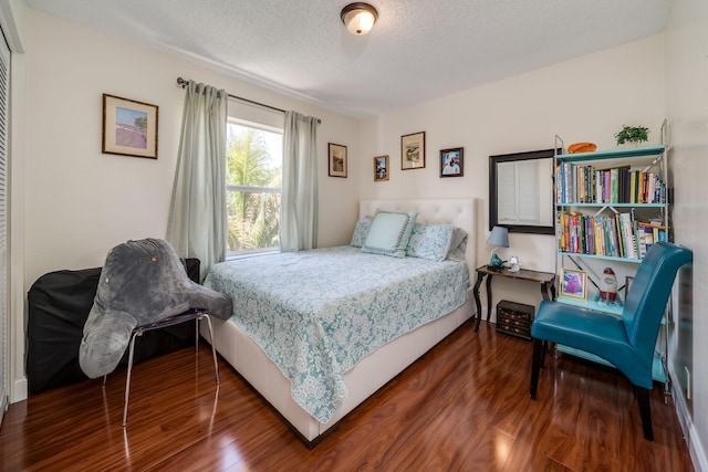 bedroom featuring dark wood-type flooring and a textured ceiling