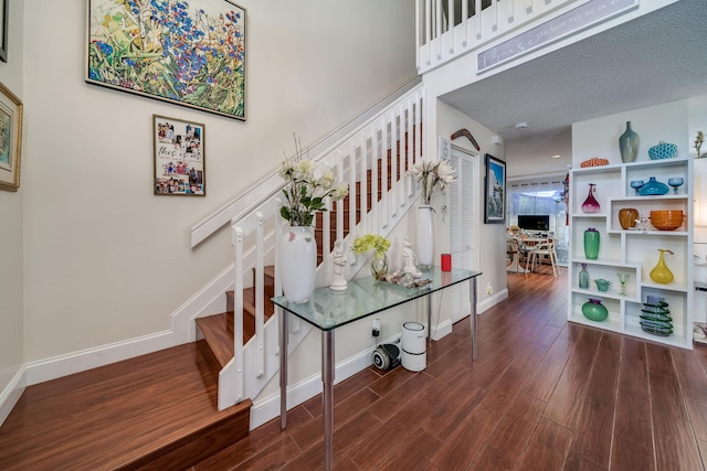 stairs featuring a textured ceiling and hardwood / wood-style floors