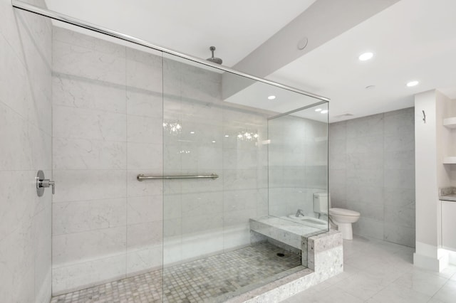 bathroom featuring toilet, a tile shower, and tile walls