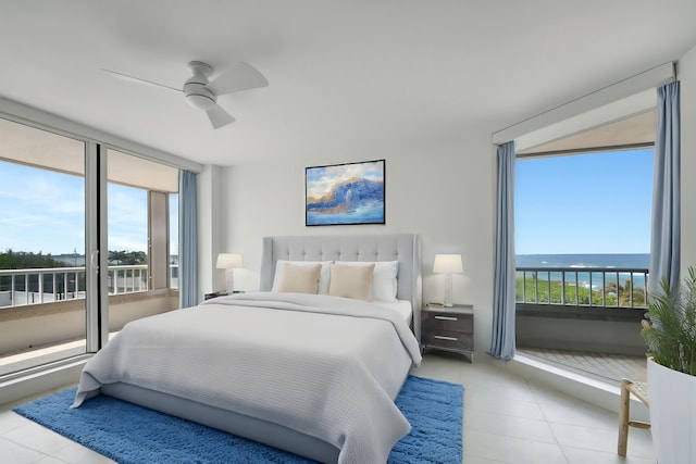 tiled bedroom with ceiling fan and a water view