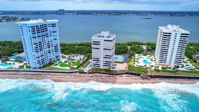 birds eye view of property with a water view and a beach view