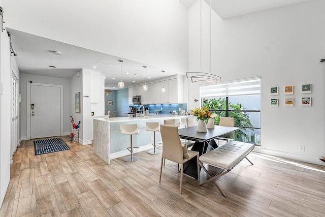 dining room featuring a textured ceiling and light wood-type flooring