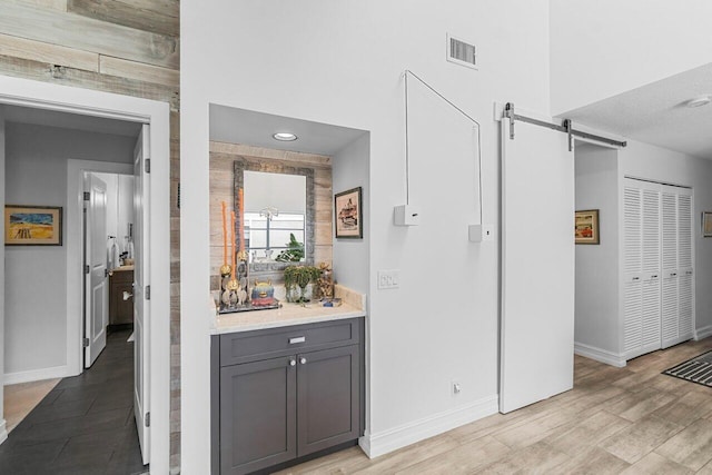 hall featuring light wood-type flooring and a barn door