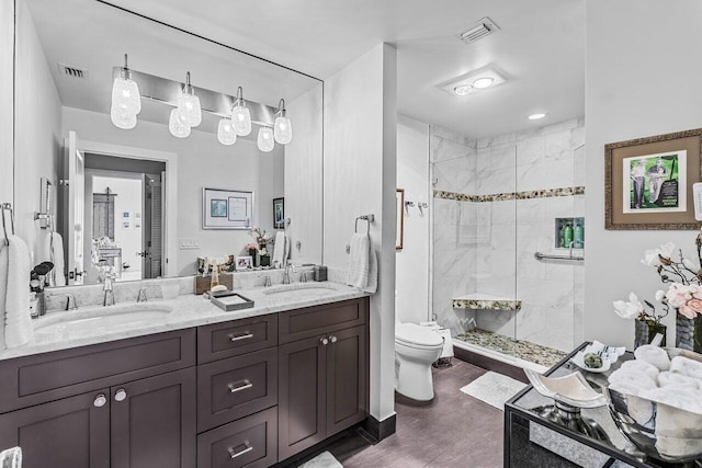 bathroom with vanity, toilet, and a shower with door