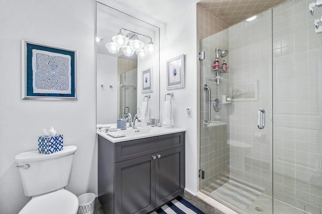 bathroom with vanity, toilet, and a shower with shower door