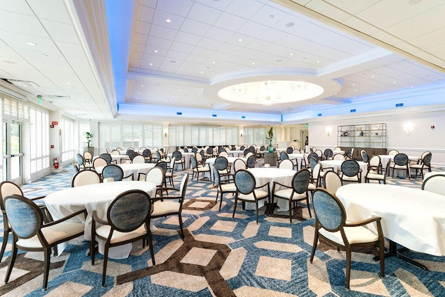 dining room featuring a tray ceiling, a healthy amount of sunlight, carpet flooring, and ornamental molding