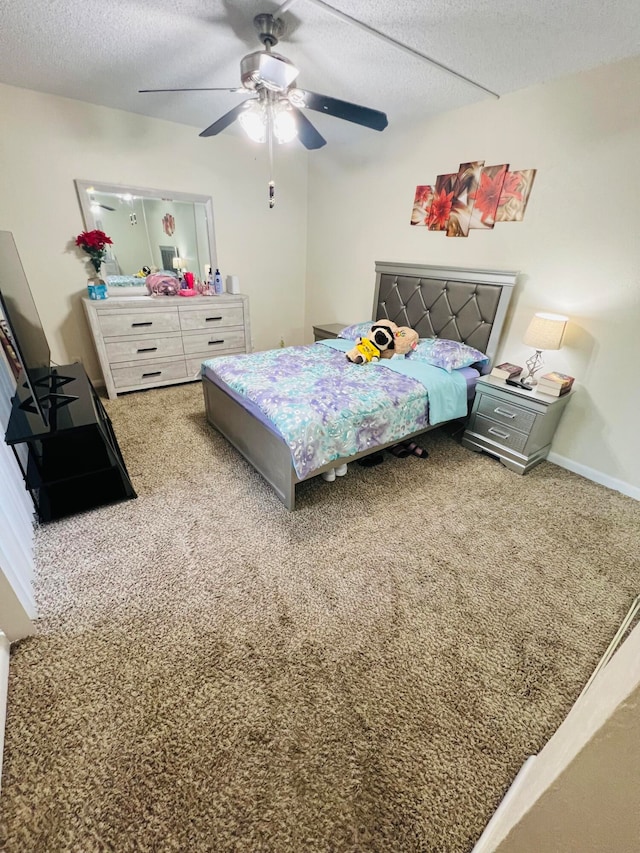 carpeted bedroom with ceiling fan and a textured ceiling