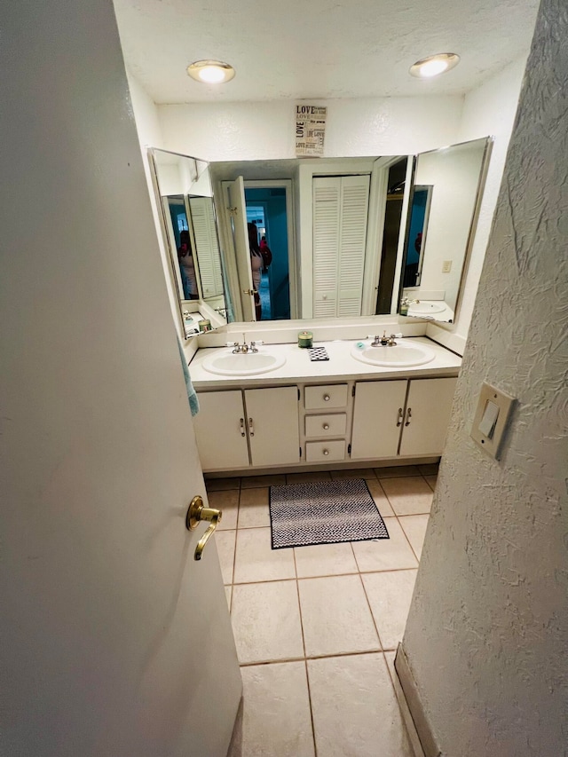 bathroom with tile flooring and dual bowl vanity