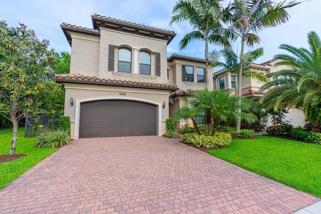 mediterranean / spanish-style house featuring a garage and a front yard