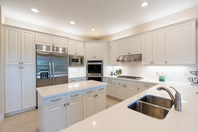 kitchen with white cabinets, light tile patterned floors, sink, and built in appliances