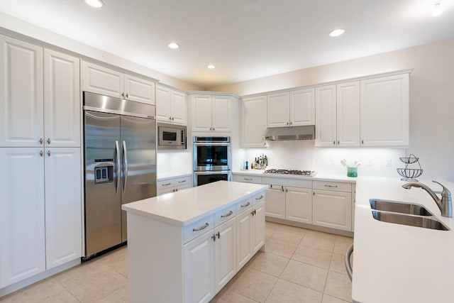 kitchen with white cabinetry, light tile patterned floors, sink, and built in appliances