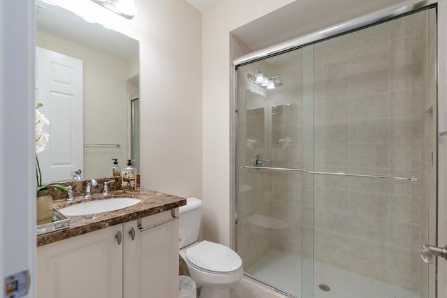 bathroom featuring vanity, walk in shower, and toilet