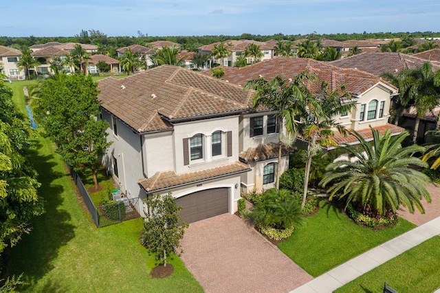 view of front of property featuring decorative driveway, stucco siding, fence, a residential view, and a tiled roof