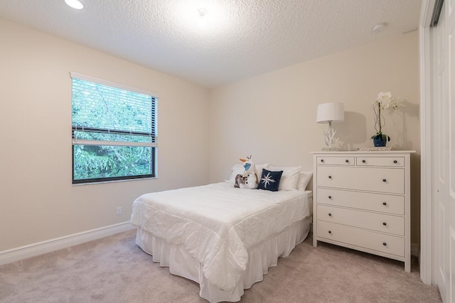 bedroom with light carpet, a closet, and a textured ceiling