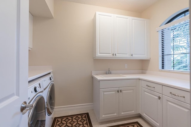 laundry area featuring sink, cabinets, washing machine and dryer, and light tile patterned floors