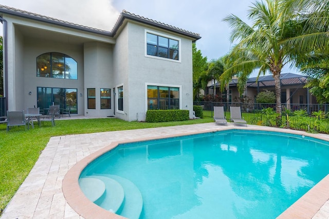 view of swimming pool featuring a patio and a lawn