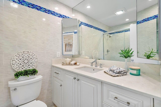 bathroom with toilet, tile walls, walk in shower, and vanity