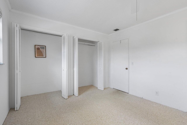 unfurnished bedroom with ornamental molding and two closets