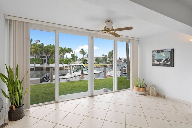 unfurnished sunroom with a water view and ceiling fan